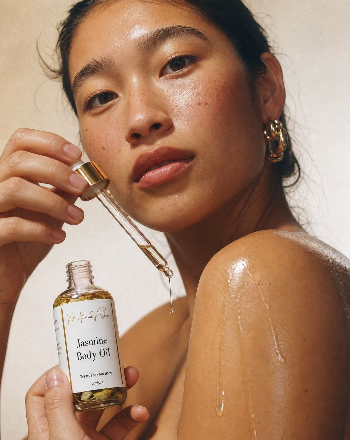 Kitt’s Kandy Shop Jasmine Body Oil being applied with a golden dropper